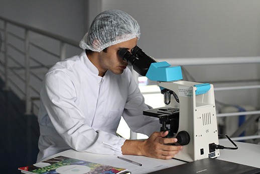 hombre usando microscopio para biologia molecular